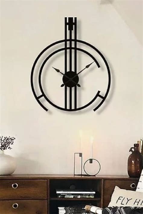 a living room with a clock on the wall next to a book shelf and vase