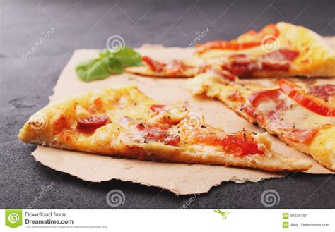 Pizza With Sausage Ham Tomato And Cheese Decorated With Basil And