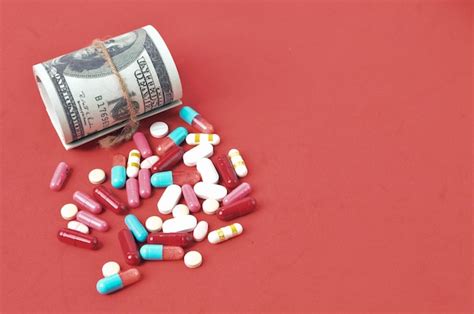 Premium Photo Pill Capsules And Money Banknote Isolated On A Red