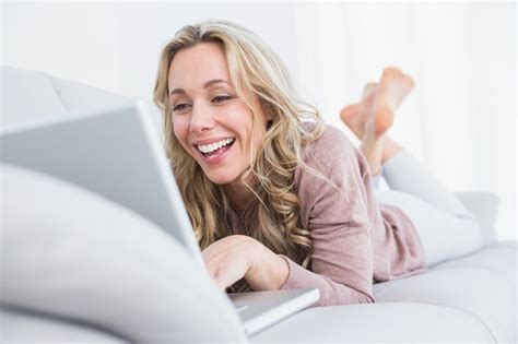 Premium Photo Happy Blonde Lying On Couch Using Laptop
