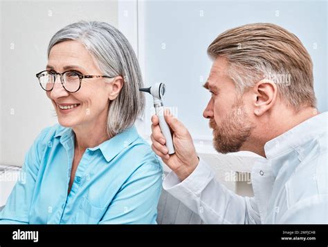 Otolaryngologist Doctor Checking Mature Woman S Ear Using Otoscope Or