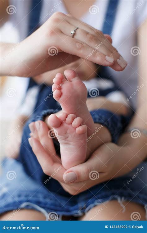 Parti Del Corpo Le Gambe Del Bambino Nelle Mani Della Madre Fotografia