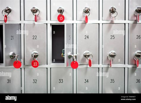 Rows of metal lockers with numbered keys with red tags for storing valuables and personal ...