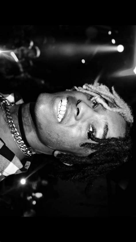 A Black And White Photo Of A Man With Dreadlocks Wearing A Checkered Shirt