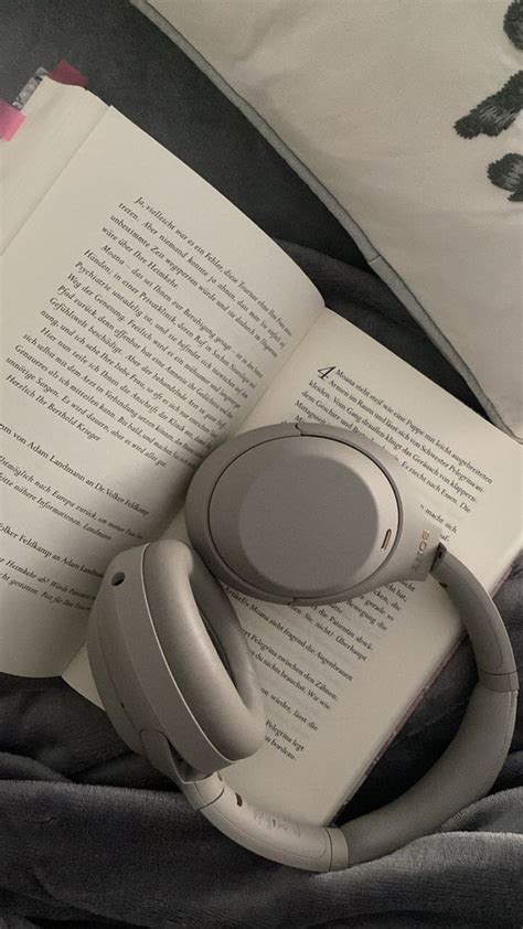 An Open Book With Headphones On Top Of It