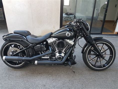 A Black Motorcycle Parked In Front Of A Building