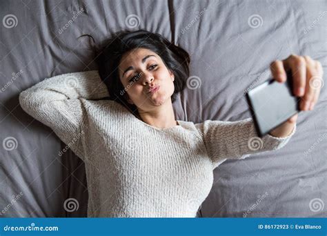 Mujer Joven Que Toma Un Selfie En Cama Imagen De Archivo Imagen De