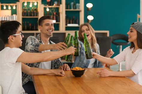 Grupo De Amigos Alegres Que Beben La Cerveza En Barra Foto De Archivo