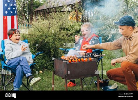 Glückliche junge Familie machen gemeinsam im Garten Grillen Menschen