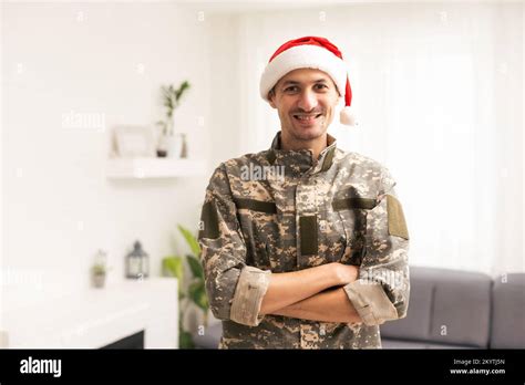 Christmas and Army. Young soldier wearing santa hat standing Stock Photo - Alamy