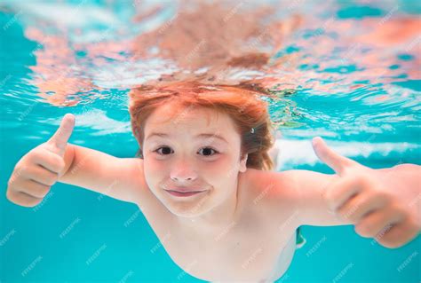 Cara De Niño Bajo El Agua Con Los Pulgares Hacia Arriba Niño Nadando En