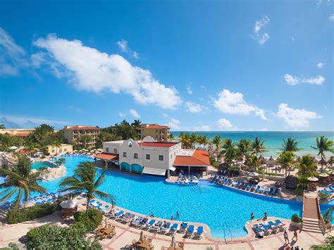 Large Pool With Resort Buildings And View Of Ocean In Background