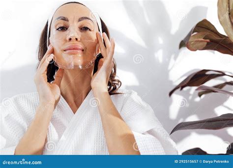 Une Femme Souriante En Peignoir Blanc S Occupe De Sa Peau Et Colle Des Taches Noires Sur Son