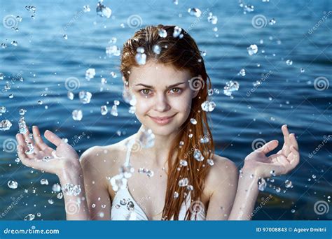 Young Beautiful Woman In A Bathing Suit In The Sea Splashing Water