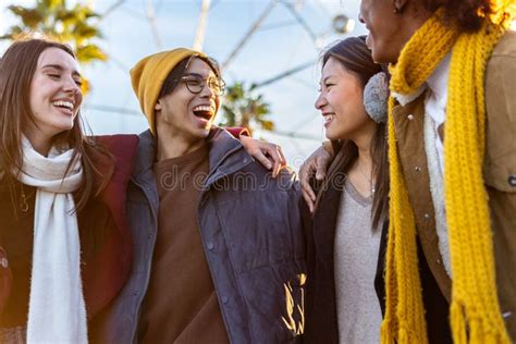 Happy Group Of Multiracial Friends Laughing While Hugging Each Other