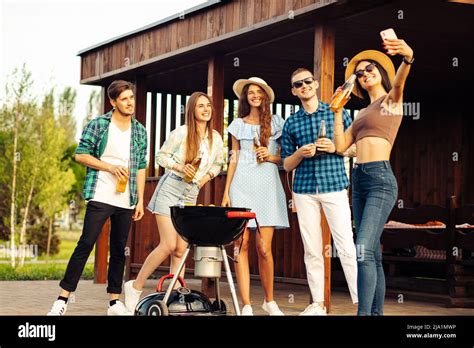 A Group Of Cheerful Young Friends Having A Barbecue Party In The