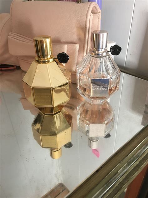 two perfume bottles sitting on top of a glass table next to a purse and ...