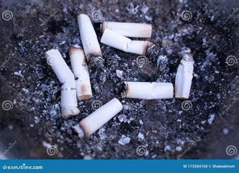 Lots Of Smoked Cigarette Buds In A Large Ash Tray On A Public Area