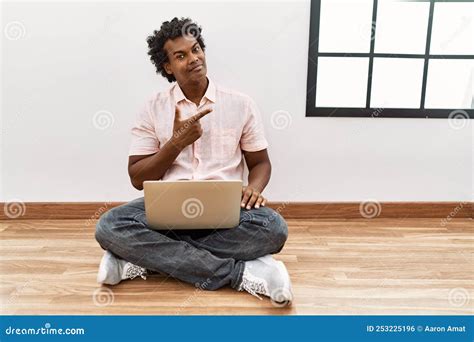 African Man With Curly Hair Using Laptop Sitting On The Floor Cheerful