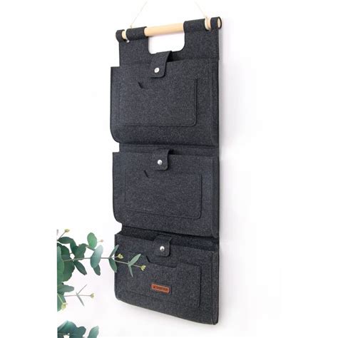 Three Pockets Hanging On A Wall With A Plant In The Foreground And