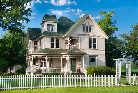 White Picket Fence Around Home With Arbor Over Entryway Gate Brick