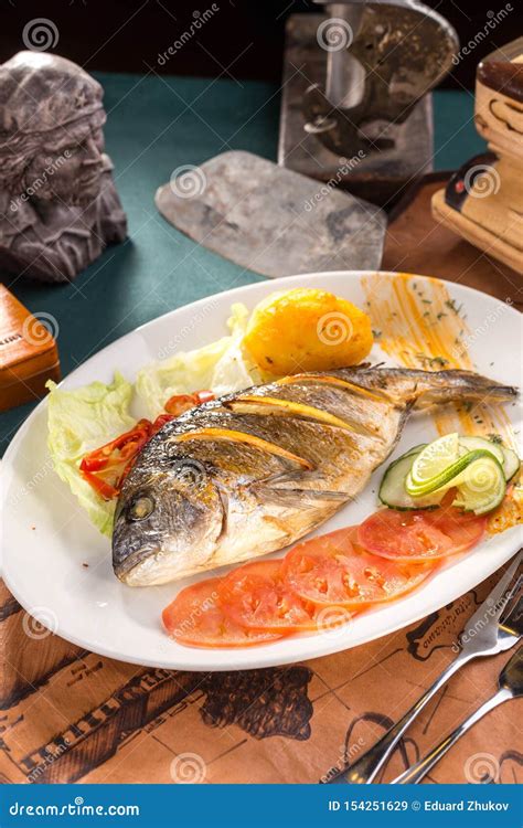 Delicious Roasted Dorado Or Sea Bream Fish With Orange Slices On White