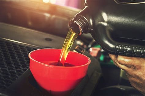 Premium Photo Car Mechanic Replacing With Pouring Oil Into Engine