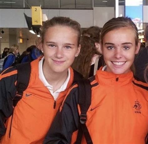 Three Girls In Orange Jackets Are Smiling For The Camera While Standing