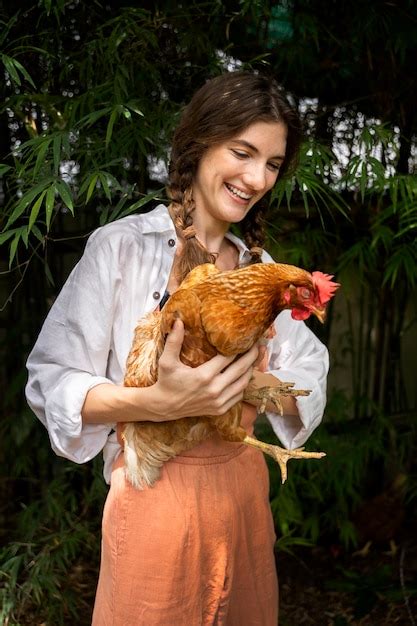 Donna Sorridente Con Colpo Medio Che Tiene Gallina Foto Gratis