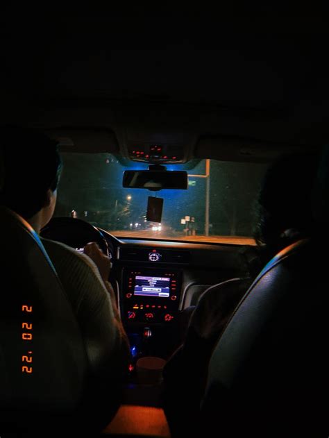 The Interior Of A Car At Night With Two People Sitting In The Driver S