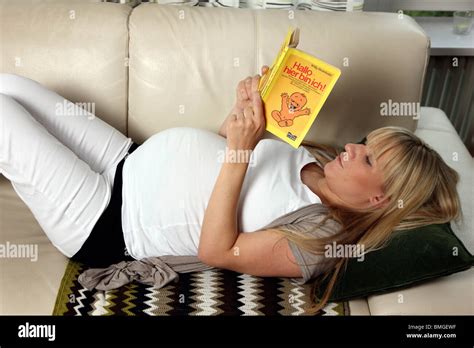 Joven Embarazada En Casa Leyendo Un Libro Sobre El Embarazo Fotograf A