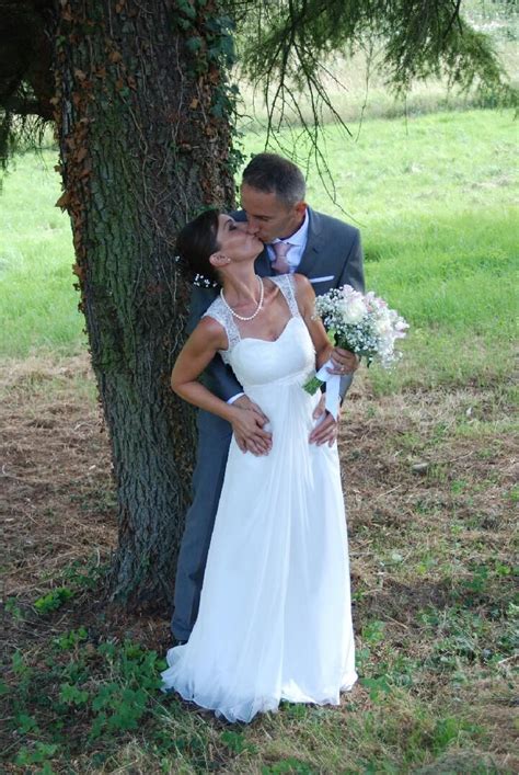 A Bride And Groom Kissing In Front Of A Tree