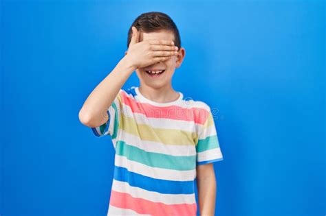 Jeune Enfant Caucasien Debout Sur Fond Bleu Souriant Et Riant Avec La