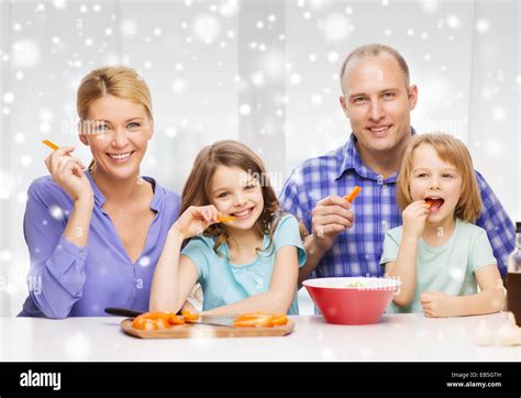 Feliz familia con dos niños haciendo la cena en casa Fotografía de