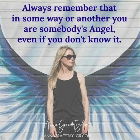 a woman standing in front of a wall with an angel wings quote