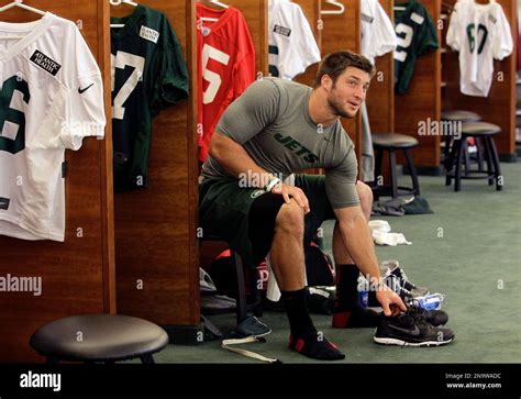 New York Jets Quarterback Tim Tebow Sits At His Locker At The Teams