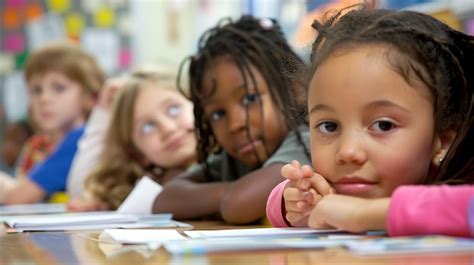 Un Grupo De Niños Sentados En Una Mesa En Un Aula Los Niños Son De Diferentes Razas Y Etnias