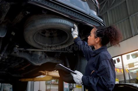 Beautiful Female Auto Mechanic Checking Wheel Tires In Garage Car