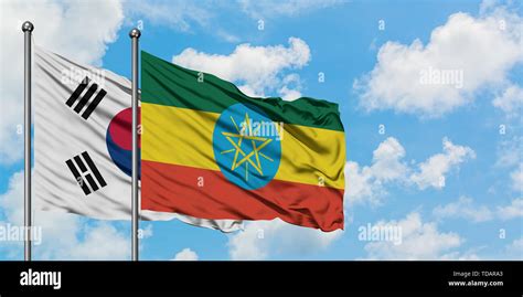 South Korea And Ethiopia Flag Waving In The Wind Against White Cloudy