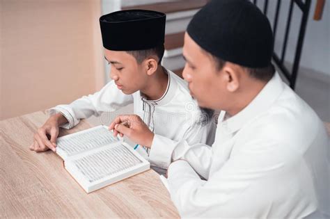 Pai Mu Ulmano Que Ensina A Seu Filho Como Ler O Quran Foto De Stock