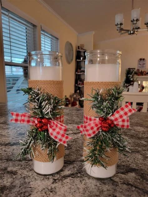 Two Jars With Christmas Decorations On Them Sitting On A Counter In