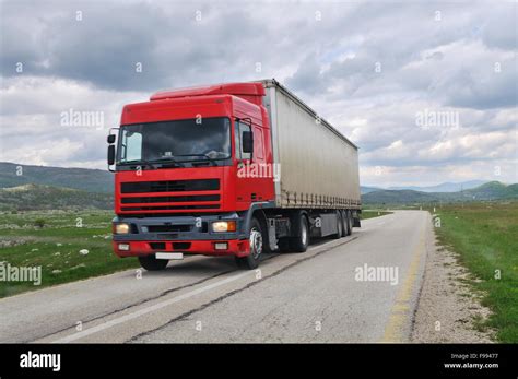 big delivery cargo red truck on road drive fast Stock Photo - Alamy