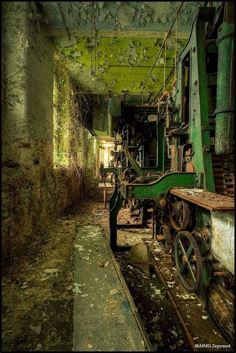 An Old Abandoned Factory With Machinery And Moss Growing On The Walls