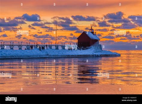 Grand Haven Lighthouse at sunset, at the mouth of the Grand River where ...