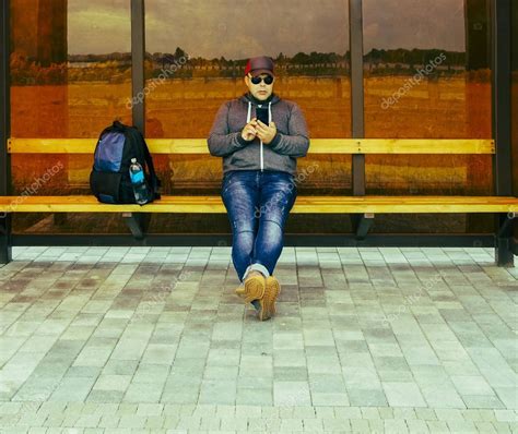 Joyful Young Man Waiting Transport Bus Stop Male Sitting Bench Stock