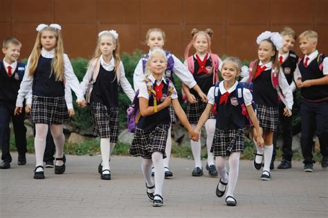 Grupo De Ni Os En Uniformes Escolares Con Mochilas Yendo A La Escuela