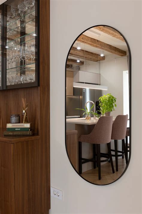 A Mirror Hanging On The Side Of A Wall Next To A Counter Top With