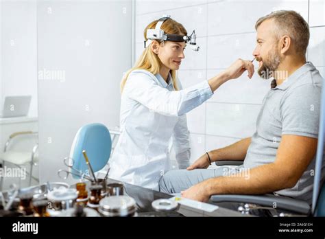 Female Otolaryngologist With Adult Patient During A Medical Examination