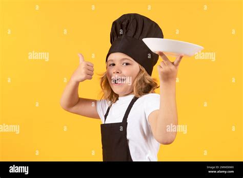 Funny child cook with cooking plate. Kid chef cook prepares food on ...