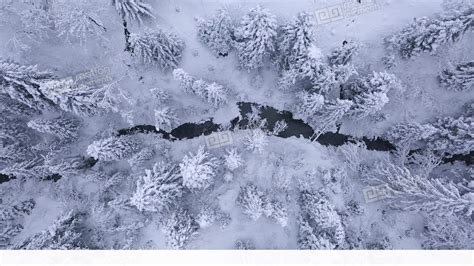 Top View Of Winter Mountain River Surrounded By Trees And Banks Of Snow